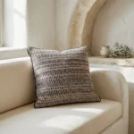 Handgewebter Kissenbezug Bodrum Stone in Schwarz, Creme & Rosé von Elly Living mit grafischem Muster und schwarzem Rand auf hellem Sofa