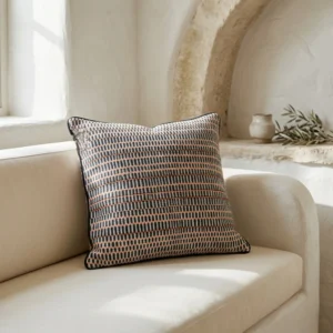 Handgemachter Kissenbezug Elara Schwarz Creme Rosé von Elly Living mit grafischem Muster und schwarzem Rand auf hellem Sofa