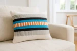 Bodrum Summer – handgewebter Kissenbezug in Creme, Türkis & Orange verkauft durch Elly Living mit modernem Streifenmuster auf hellem Sofa