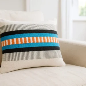 Handgemachter Kissenbezug Azura Creme Türkis Orange von Elly Living mit modernem Streifenmuster auf hellem Sofa
