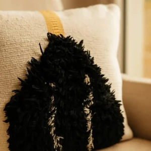 Handgemachter Kissenbezug Nera Beige Schwarz von Elly Living mit schwarzem Strukturmuster auf hellem Sessel