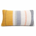 Handgemachter gestrickter Kissenbezug Solea Senfgelb Creme Grau von Elly Living auf heller Sitzbank im mediterranen Wohnstil